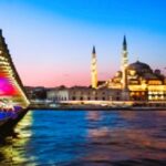 Side view of Istanbul’s skyline at sunset, with domes, minarets, and the Bosphorus glowing in soft light.